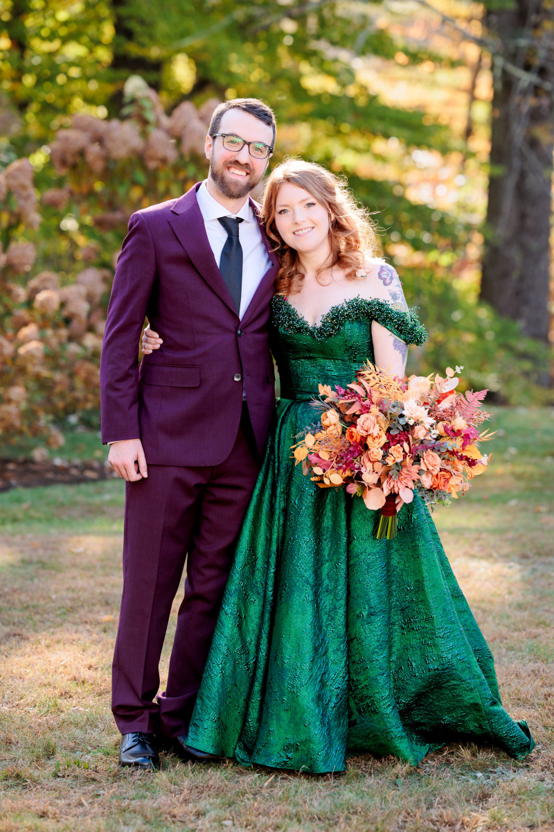 Bride and groom with a faux rust, burgundy and orange bridal bouquet during an autumn wedding.