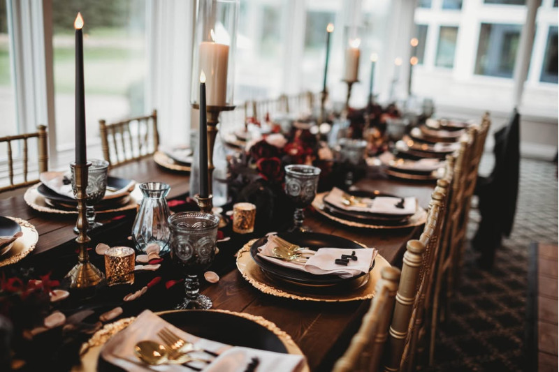 Wedding table centerpiece in burgundy, beige, black, and gold with silk flowers