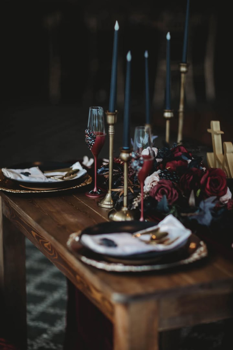Moody floral arrangement for reception table in burgundy, beige, and gold tones