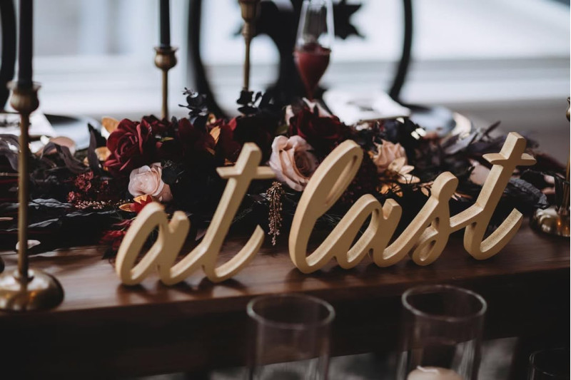 Elegant faux table flowers in black, burgundy, and beige with gold accents