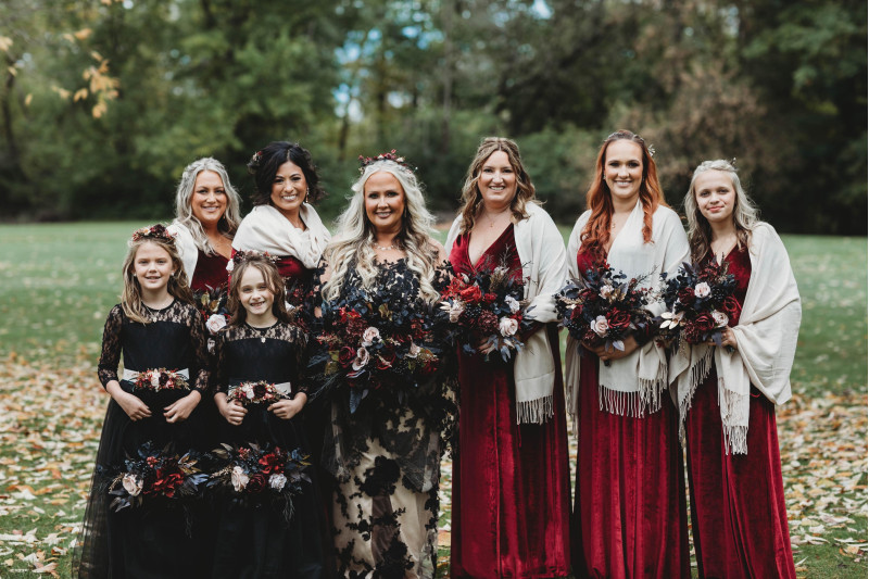 Dark romantic wedding bouquet in burgundy, beige, black, and shimmering gold