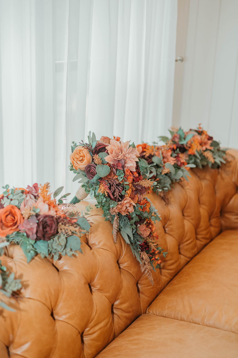 Bridal bouquet in burgundy, dusty rose, terracotta, and rust with silk flowers