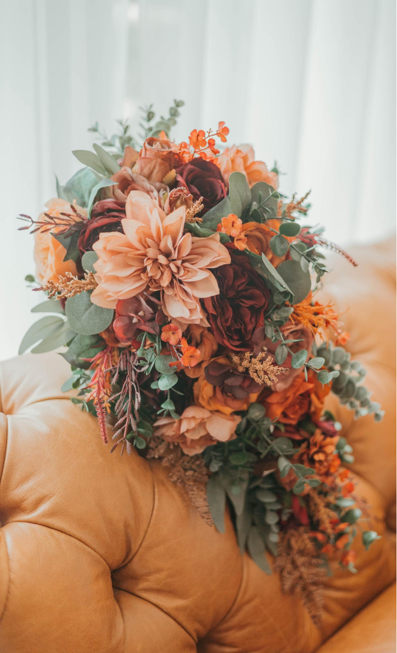 Artificial bouquet featuring terracotta, burgundy, dusty rose, and rust florals