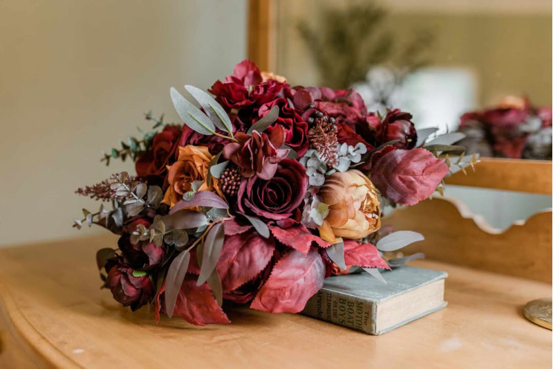 Rust, Burgundy & Cinnamon bridal bouquet arrangement with roses and eucalyptus on wooden table1080-533.33333333333
