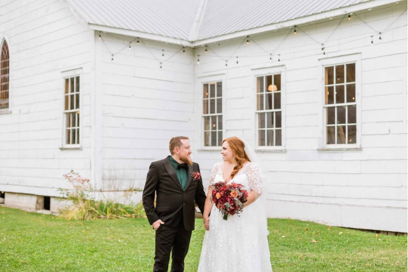 Rust, Burgundy & Cinnamon wedding bouquet with bride and groom outside white chapel1080-533.33333333333