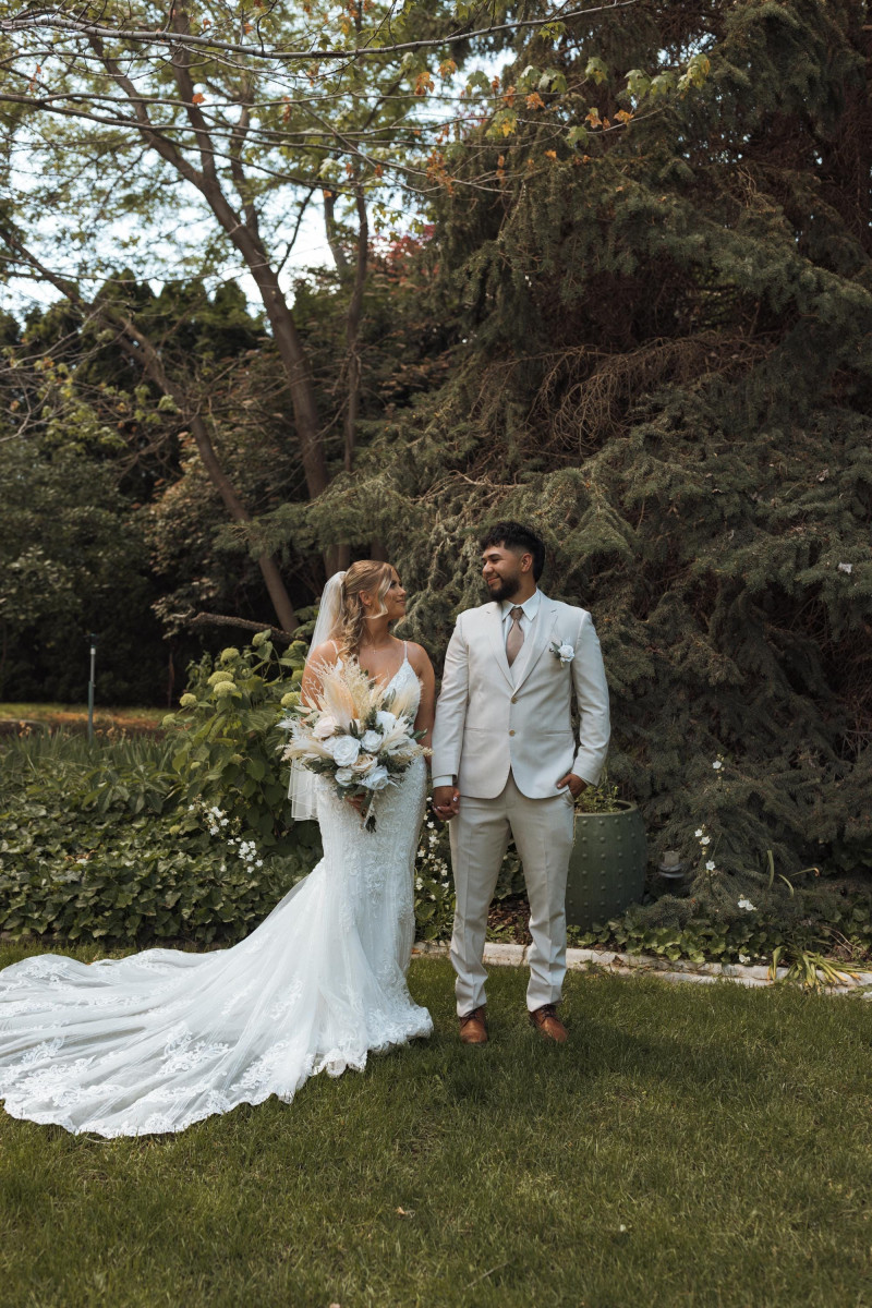 Bride and groom in garden with ivory and beige pampas wedding bouquet
