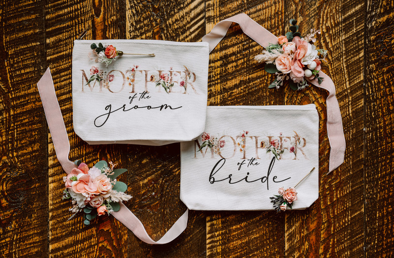 Mother of the groom and mother of the bride wedding bags with peach and blush pink floral corsage and boutonniere