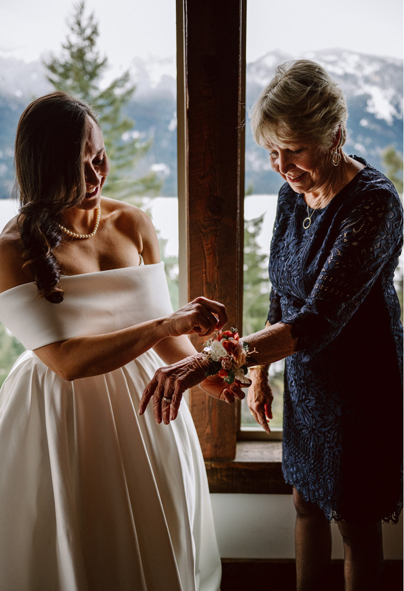 Mother of the bride corsage with peach and blush pink flowers during wedding preparation
