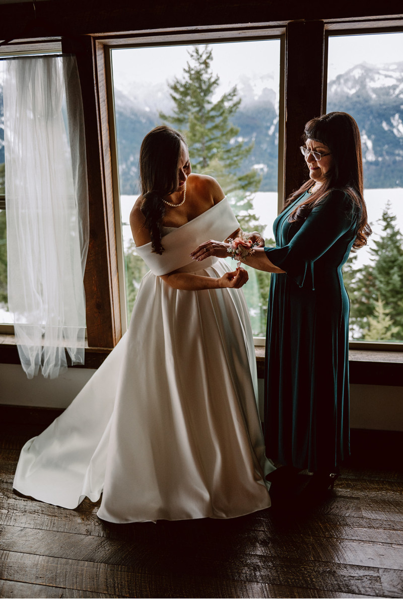 Bride and mother adjusting peach and blush pink wedding corsage