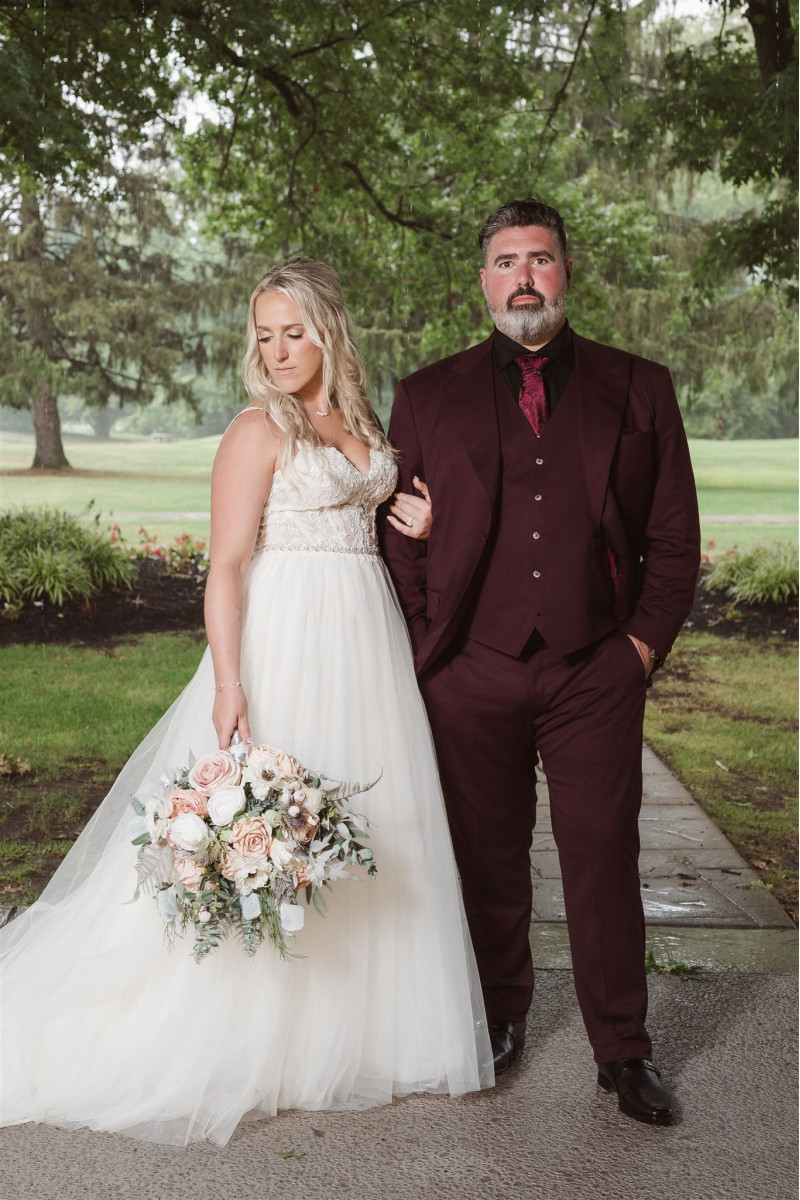 Wedding bouquet and groom boutonniere in blush pink, white, and beige for a romantic couple portrait