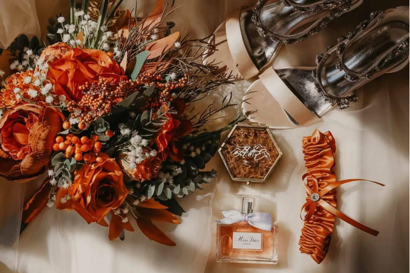 Cascading bridal bouquet in rust, terracotta, and burnt orange with flowing silk flowers