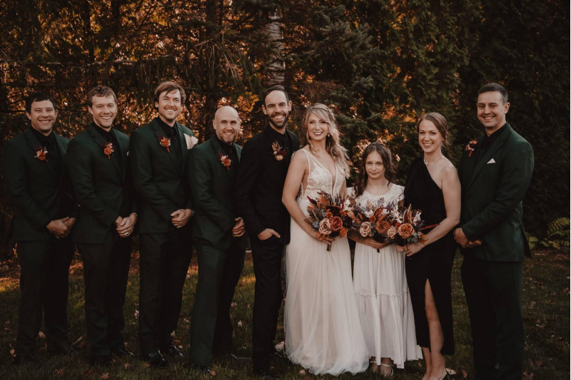 Coordinated wedding flowers in burgundy and terracotta for bridal party and groom