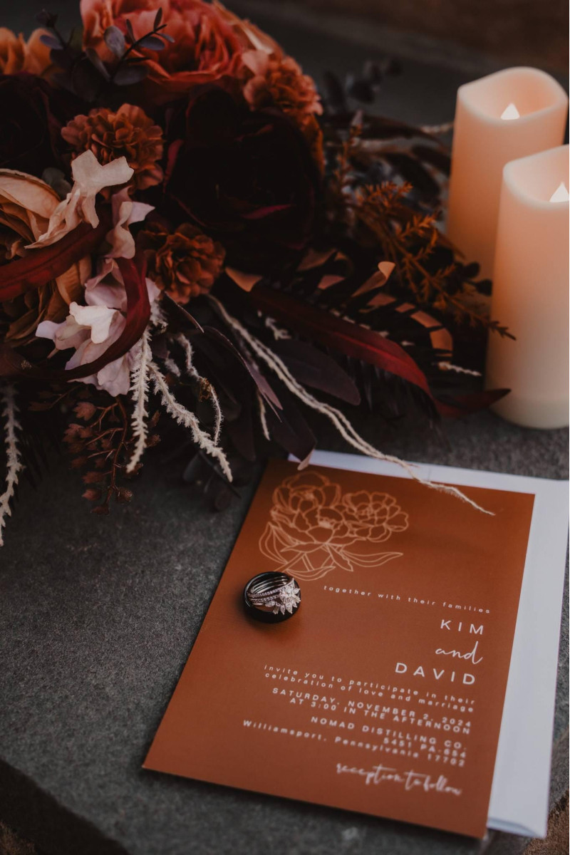 Burgundy and terracotta wedding floral details with moody autumn styling