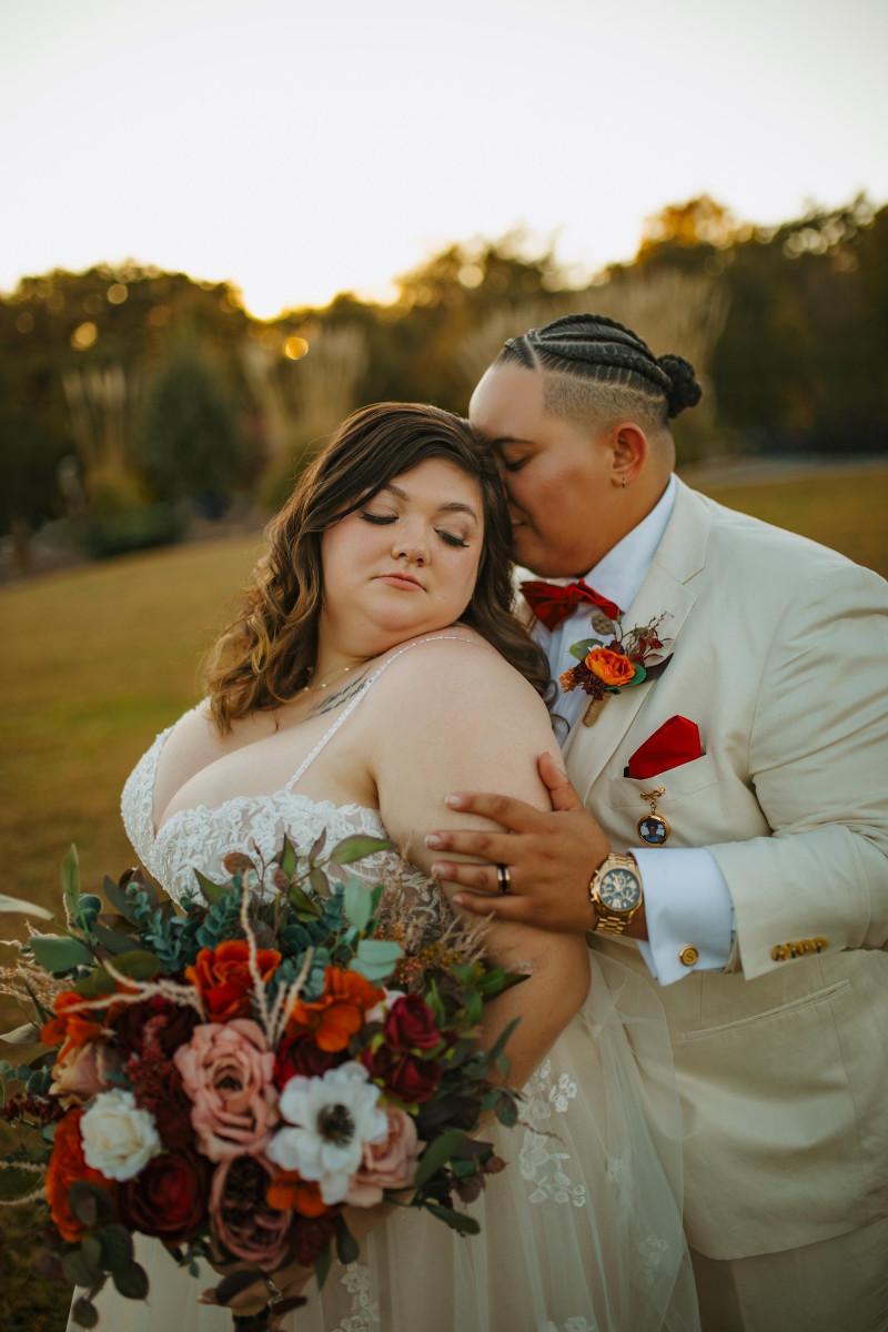 Burgundy, rust, ivory, and cinnamon bridal bouquet with matching groom boutonniere