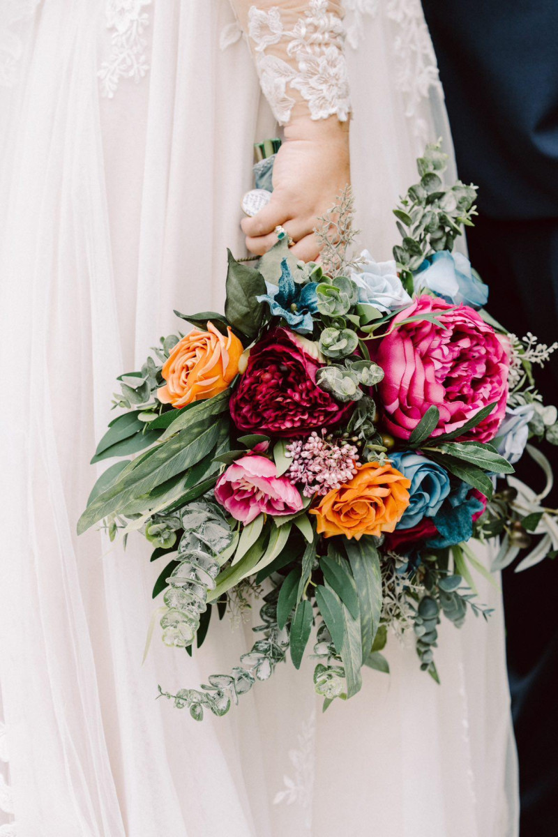 Dramatic bridal bouquet in emerald green, orange, teal, and magenta for a vibrant wedding look1170-1200