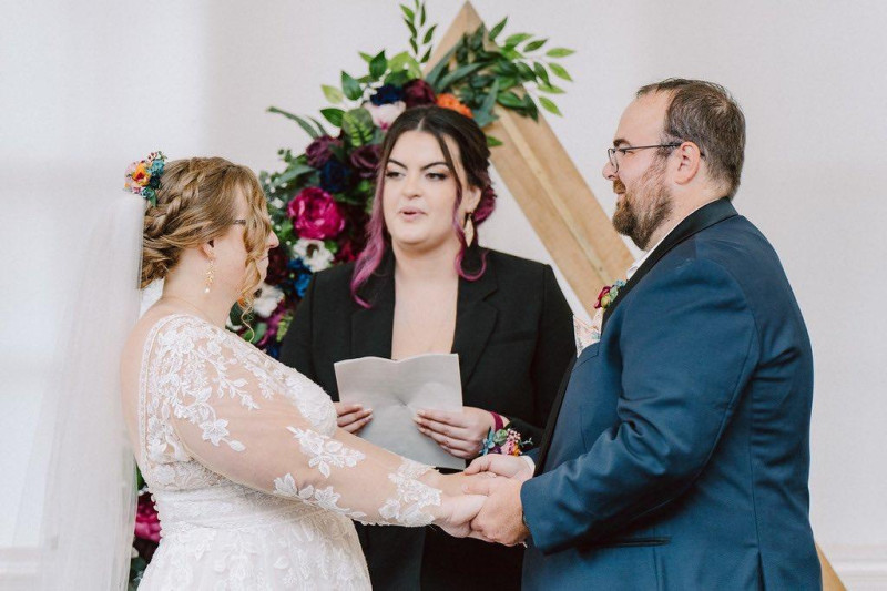 Colorful faux flower arch in jewel-tone palette with vibrant emerald, orange, and magenta hues1024-533.59375