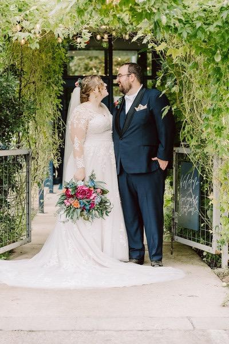 Colorful bouquet in jewel tones featuring magenta peonies, teal roses, and orange accents