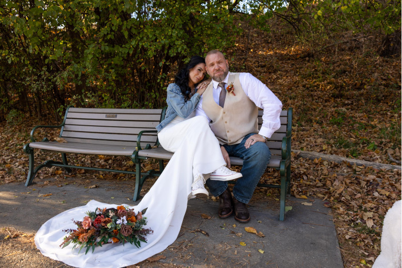 bride and groom sitting with terracotta, cinnamon, rust and ivory bridal bouquet