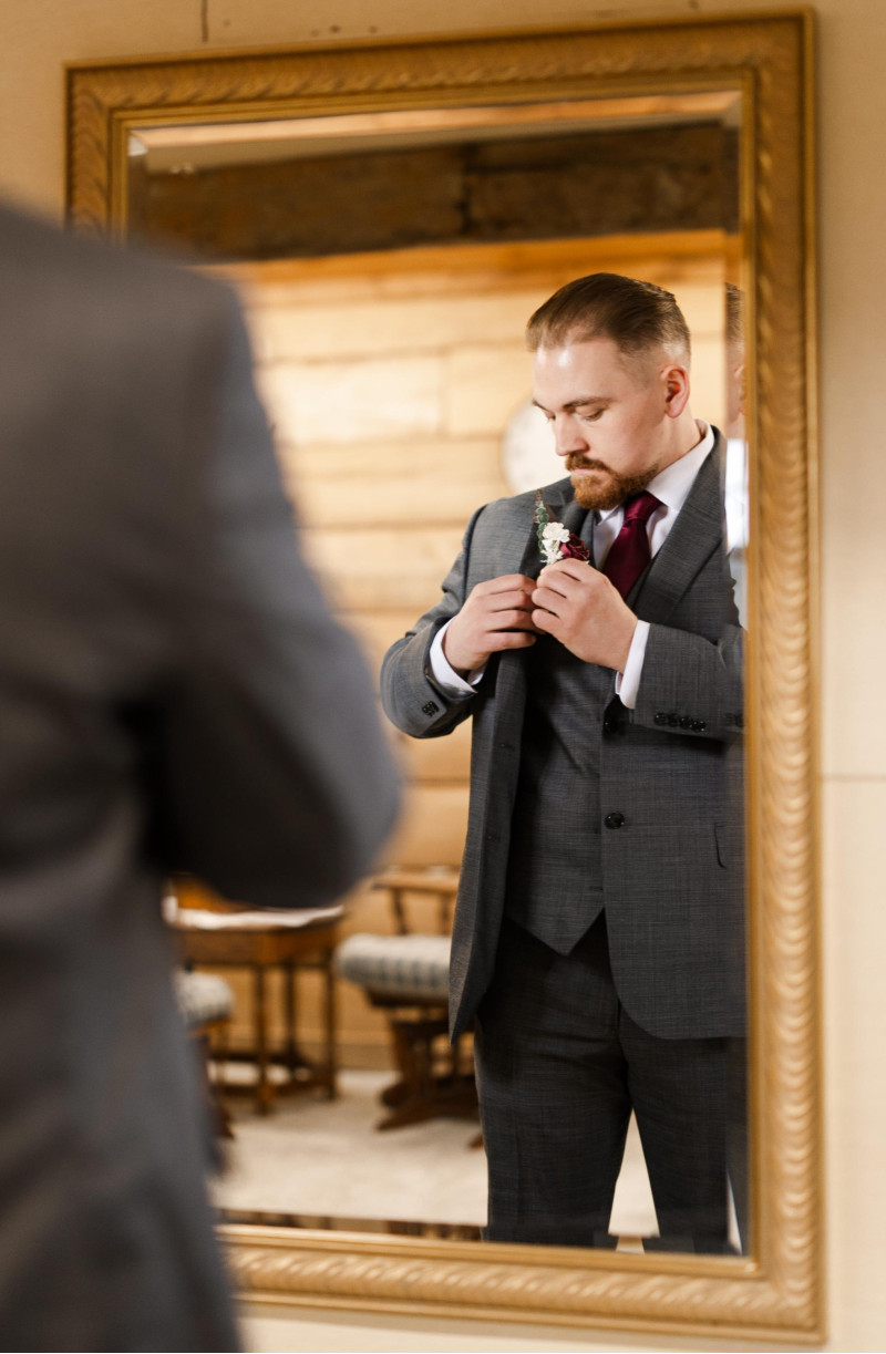 Groom’s wedding boutonniere with burgundy rose and ivory floral accents
