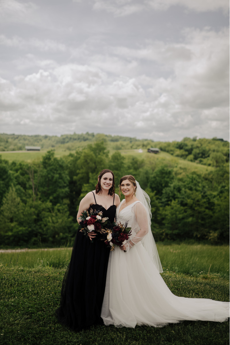 Moody bridal bouquet with burgundy and black roses, and ivory peonies