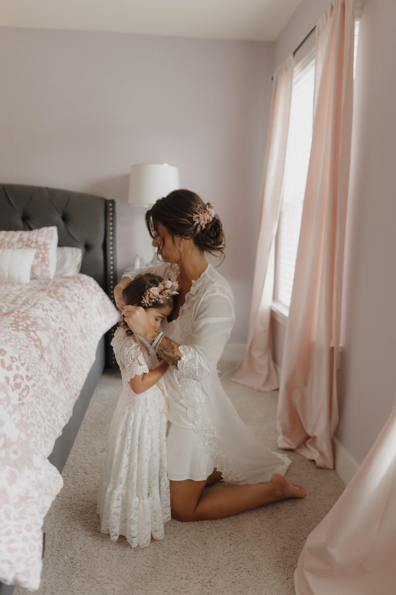 bride with flower girl in bedroom, beige mocha and burgundy wedding styling, floral crown and bridal hair comb