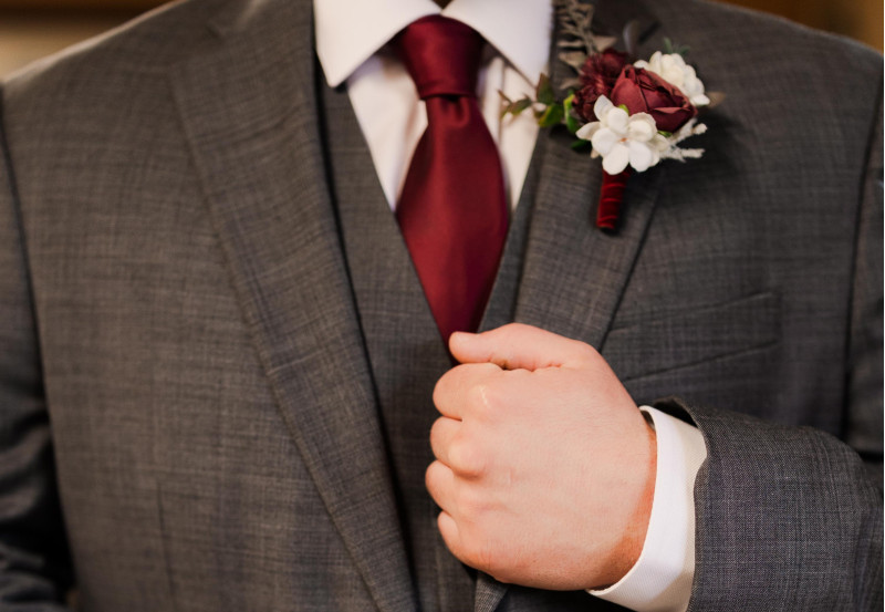 Burgundy and ivory wedding boutonniere with silk flowers for the groom