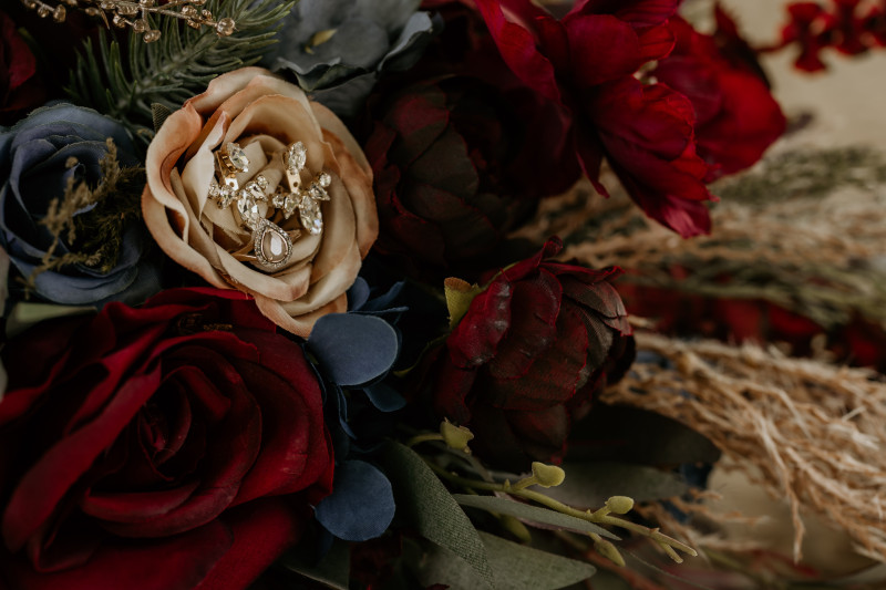 Burgundy navy blue and gold wedding bouquet detail with bridal earrings deep red roses and navy blooms8192-533.59375