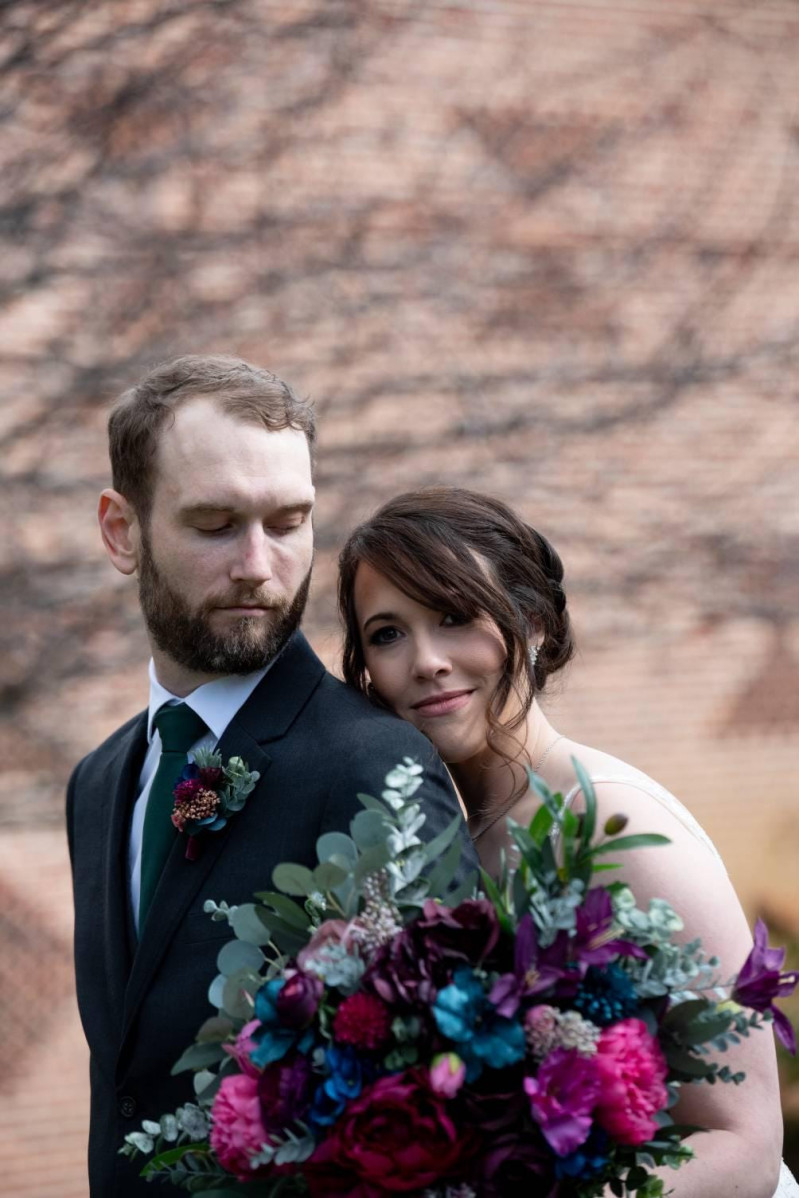 Jewel tone wedding collection, bride and groom close portrait with burgundy, plum and teal bouquet and boutonniere