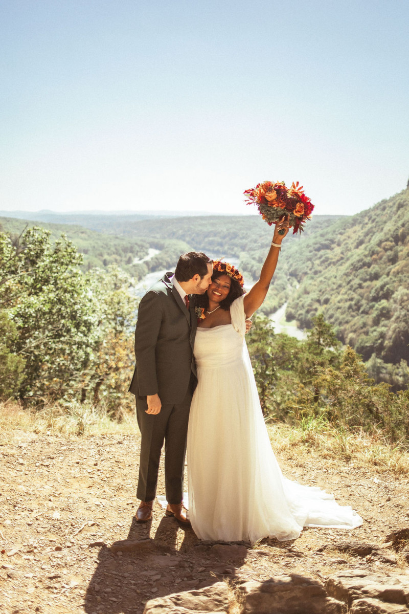 Wedding bouquet in warm autumn tones with rust, burgundy, and orange flowers