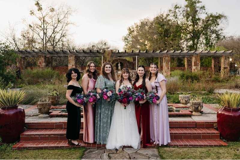 Jewel-tone wedding bouquets with emerald green, magenta, teal, and purple flowers for bride and bridesmaids