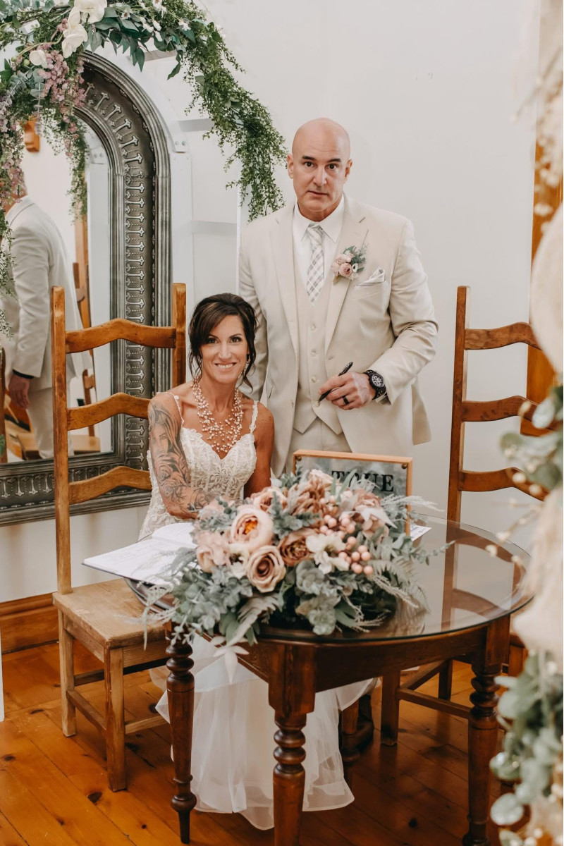 Blush pink, beige and ivory faux bridal bouquet with eucalyptus greenery held by a bride during an autumn wedding