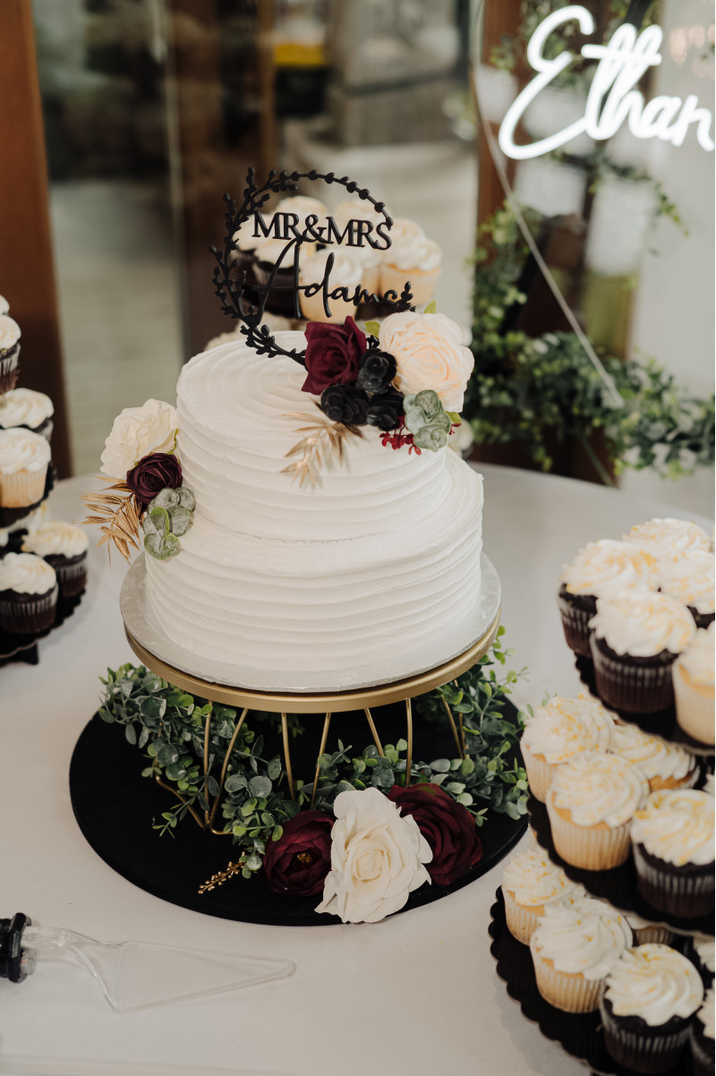 Faux wedding cake flowers in burgundy, black, gold, and ivory with silk blooms