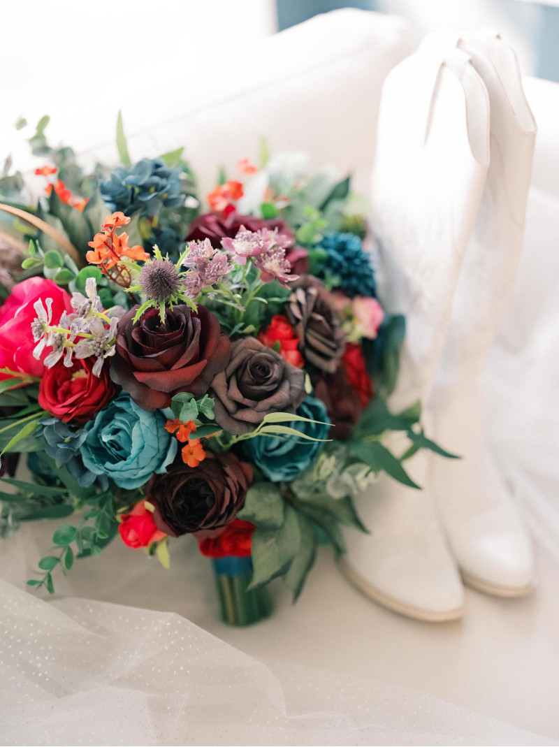 Jewel-tone bridal bouquet with emerald green, magenta, teal, and deep purple flowers