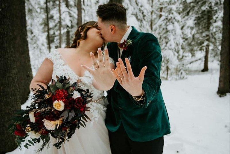 Bride with burgundy gold ivory wedding bouquet in snowy forest