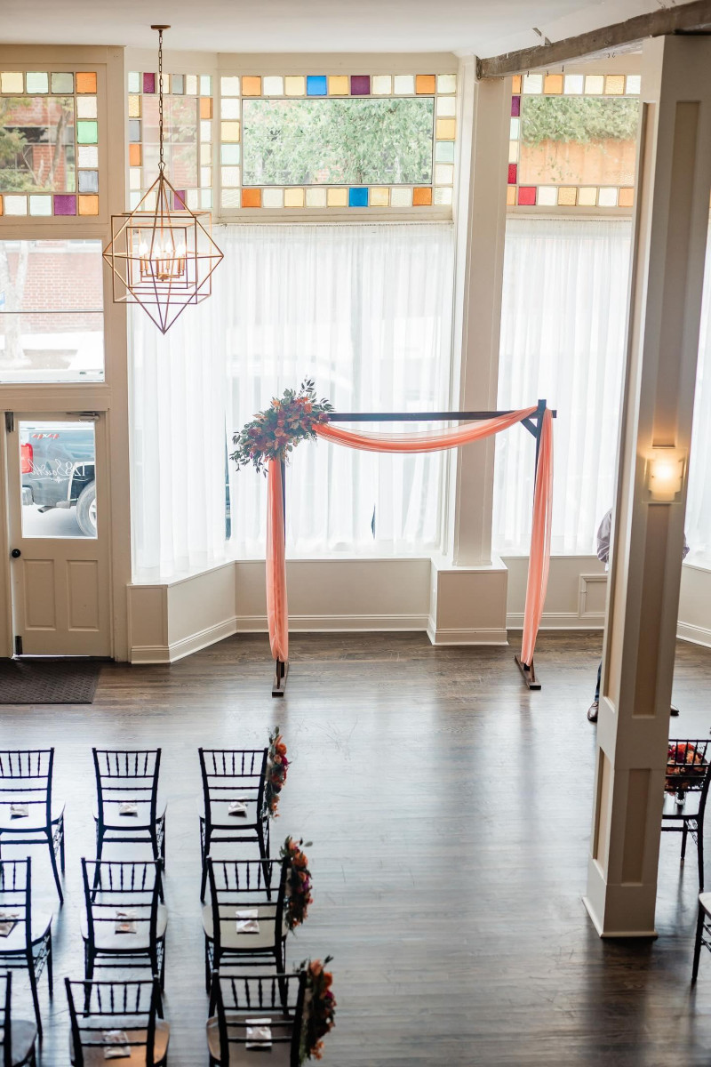 Magenta peach and coral faux floral ceremony arch arrangement with greenery