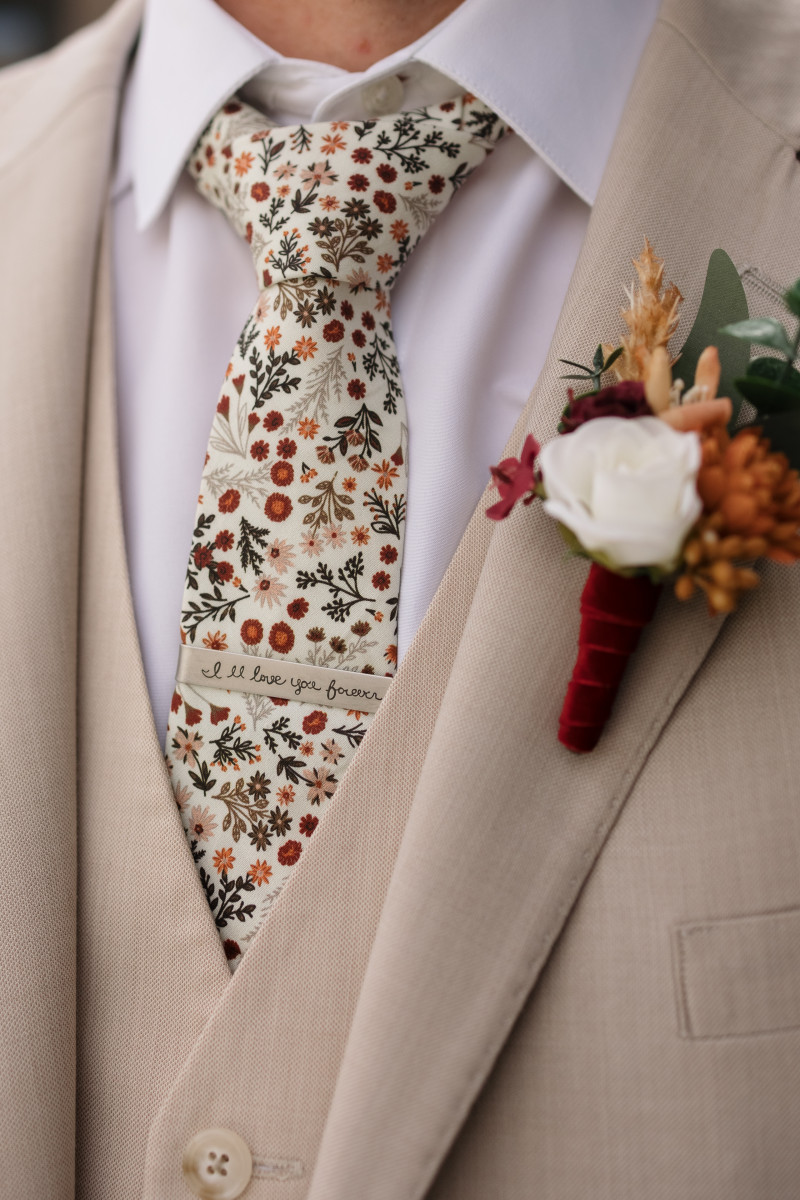 Boho groom’s boutonniere with pampas grass, cinnamon dahlia, ivory rose, and burgundy accents