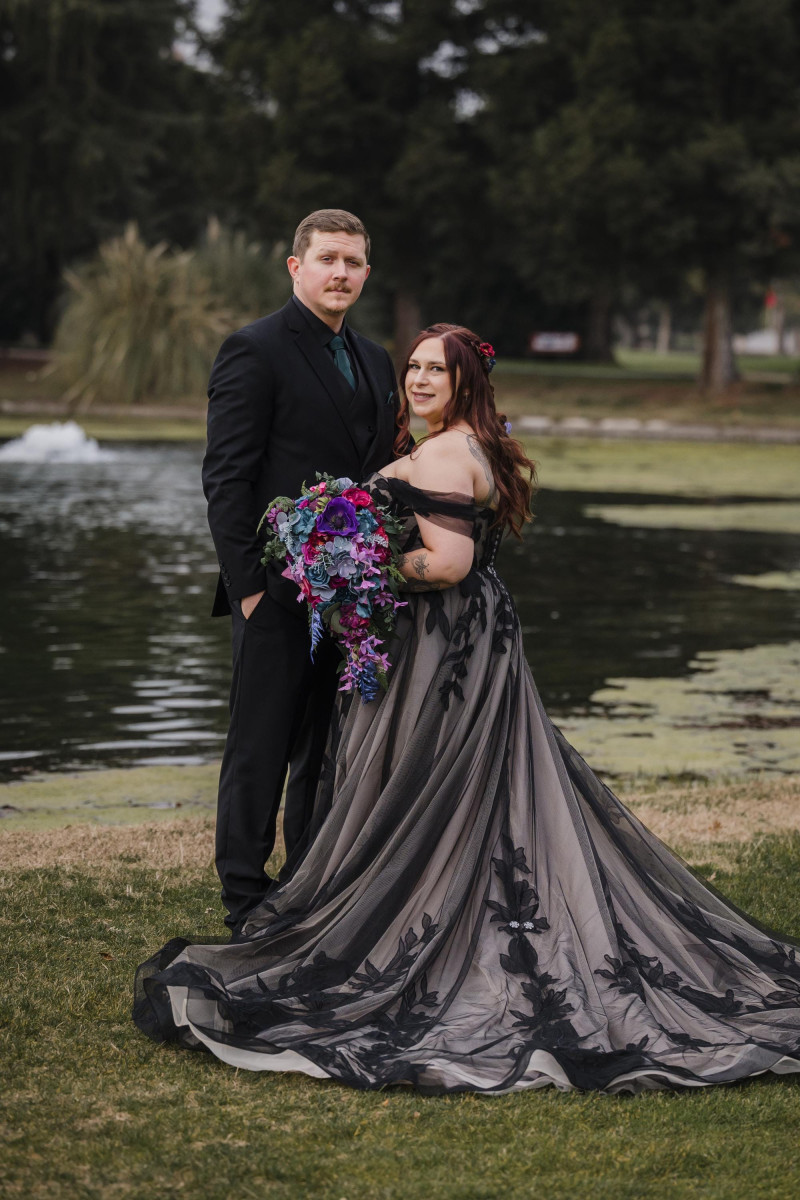 Moody jewel tone wedding couple with cascading purple and burgundy bouquet