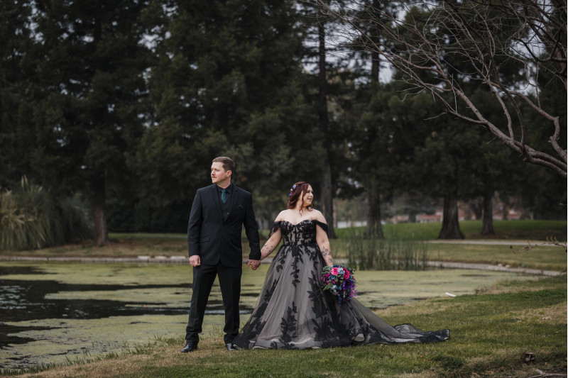 Jewel tone wedding couple with cascading purple, magenta and blue bridal bouquet