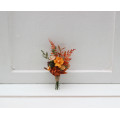 Wedding boutonniere in terracotta, rust and orange colors